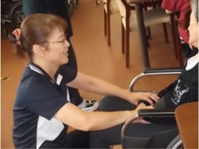 スタッフのケアシーン スタッフ２ 心温まるケアで支えるスタッフの一瞬を垣間見る場面。共感とやりがいを感じる職場の雰囲気が伝わる光景です。