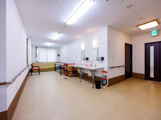 手洗い場のある廊下 廊下   手洗い場と休憩用の椅子があり、作業動線をイメージしやすい明るい廊下です。窓から自然光が入り、清潔感のある空間です。