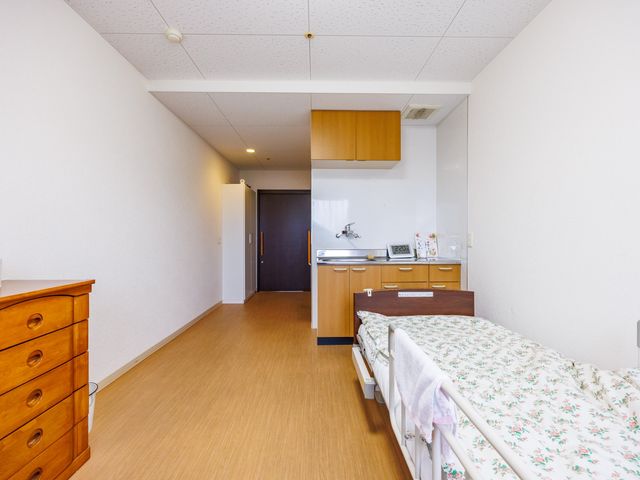 明るい居室 居室   木目調の家具が置かれた、すっきりした居室です。ベッド横に洗面設備があり、生活しやすいつくりが伝わります。