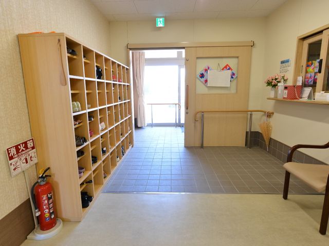 玄関ホールと靴箱 玄関 温かみのある色合いのエントランスホールは、広々としており、靴を整理するための大きな靴箱も完備しています。明るく清潔感のある手入れが行き届いた空間で、訪れる方々をお迎えします。
