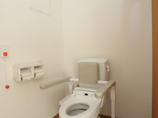 バリアフリートイレの内観 トイレ 安全かつ使いやすい設計のトイレ環境です。手すりや緊急呼び出しボタンが装備され、安心してご利用いただけます。