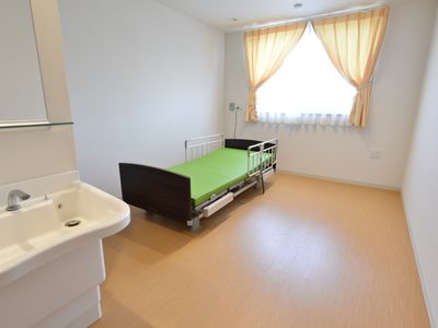 洋室のベッドと洗面台