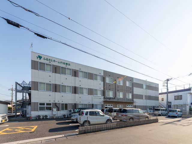 建物外観の駐車場 外観   落ち着いた色合いの建物で、駐車スペースが前面に確保されています。明るい時間帯の外観が見え、通勤時の出入りをイメージしやすいです。
