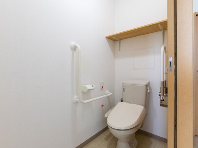 手すり付きトイレ トイレ 手すりが複数設置された、使いやすいトイレです。上部に棚もあり、落ち着いた印象です。
