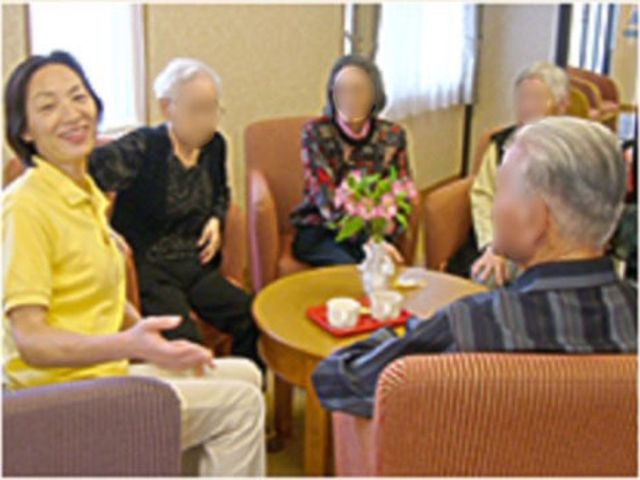 和やかな会話のラウンジ 日常 リラックスした雰囲気の中、利用者同士が丸いテーブルを囲み楽しい会話を交わしています。職員としても、このような温かいコミュニケーションが魅力の一つです。