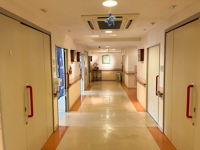 手すり付きの綺麗な廊下 廊下 明るく清潔な廊下が広がっており、働きやすい環境が整っています。スタッフのための安全な通路も確保されています。