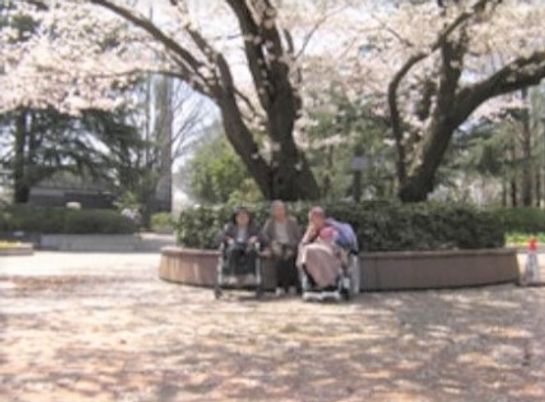 桜の下の笑顔のスタッフ
