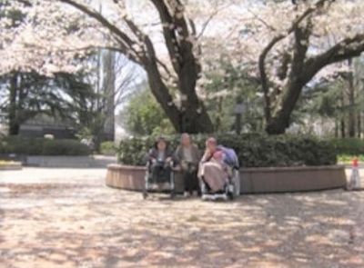桜の下の笑顔のスタッフ