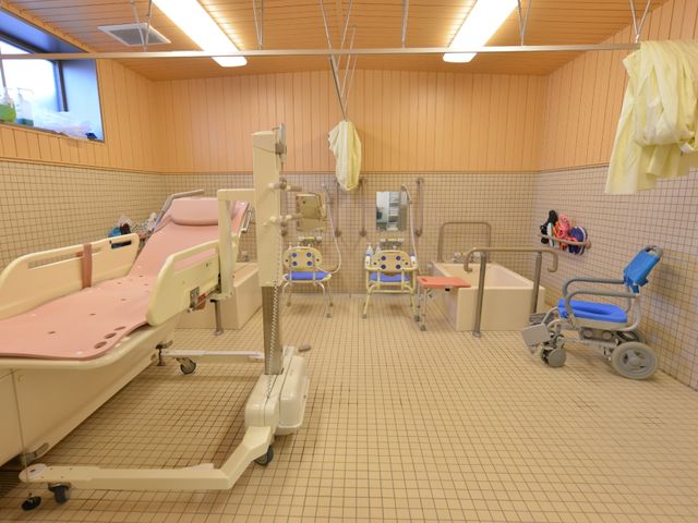 ゆったり浴室設備 お風呂場 手すりや椅子が備え付けられた清潔な浴室です。利用者の安全と快適さを考えた設計になっており、働く側も使いやすく感じられます。