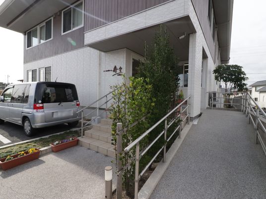  白壁の施設入口外観  