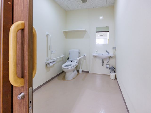 手すり付きトイレ トイレ   手すりが複数あり、動作を支えやすいトイレです。洗面台も備わり、清潔感のある明るい空間になっています。