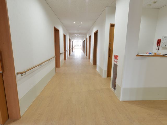 清潔な施設の廊下 廊下 手すりが設置された広々とした廊下は、明るく清潔感があり歩きやすそうです。動線に配慮された設計で、安心してお仕事ができる環境です。