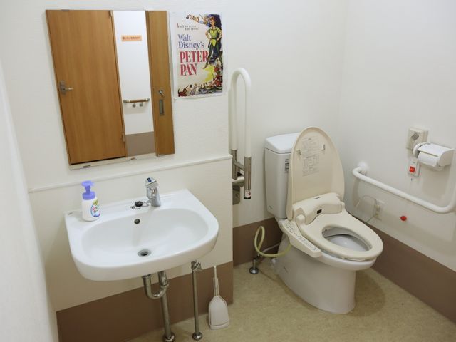 清潔感のあるトイレ空間 トイレ 手すりが設置された清潔なトイレは、利用者の安全と快適さを確保しています。緊急時を考慮した設計で、安心して勤務できる環境です。