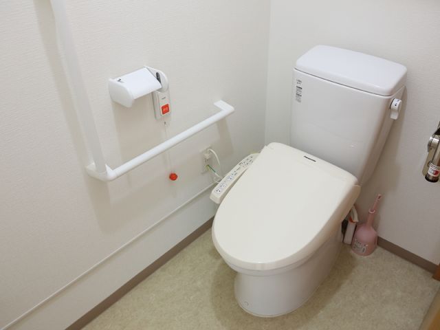 手すり付きトイレの設備 居室トイレ 安全に配慮した手すりが完備されたトイレです。緊急時には呼び出しボタンもすぐ手の届くところにあります。