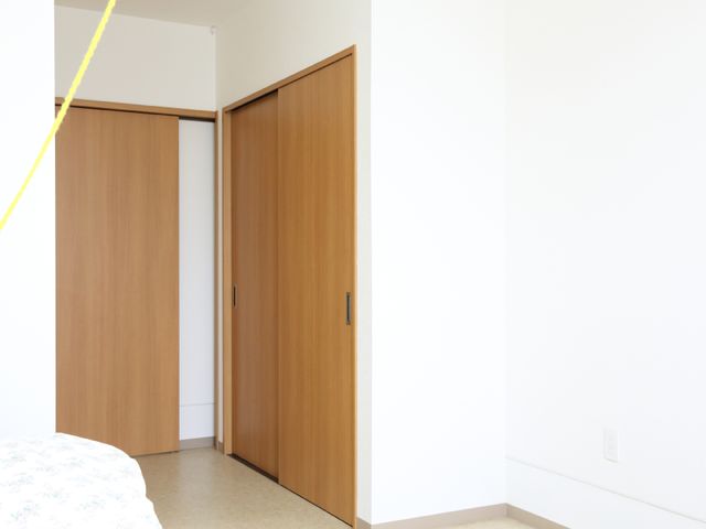 清潔な居室のクローゼット 居室入口 シンプルで清潔感のある居室には、広々とした収納スペースが完備されており、快適な個人空間を確保できます。