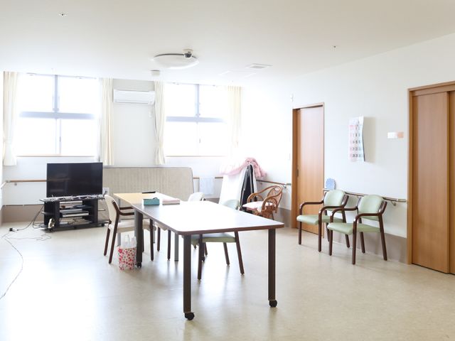 共用リビングの風景 応接室 テレビやテーブルが配された共用リビングで、リラックスしながら交流の場を楽しめます。明るく広々とした空間が日々の憩いの場となっています。