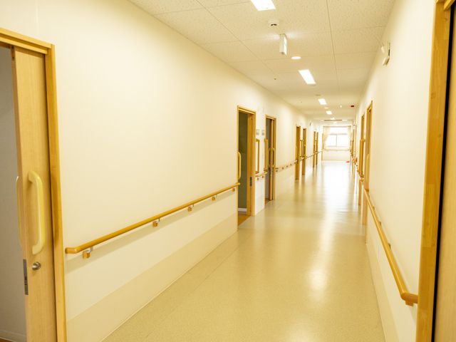 明るい廊下 廊下 手すりが備わった温かみのある廊下です。明るくて安全な移動を支援します。
