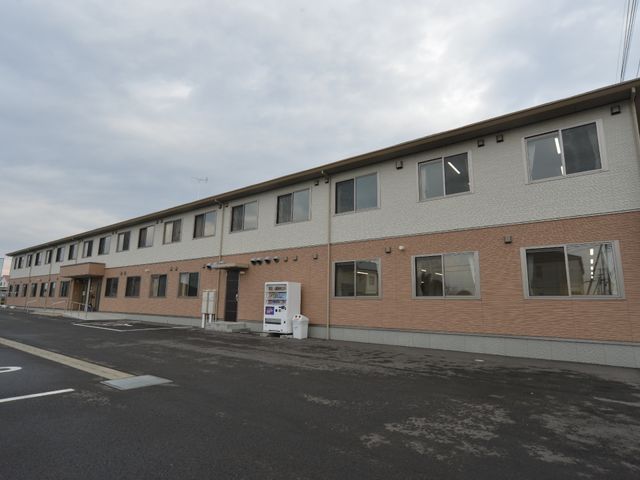 明るい外観の建物正面 施設外観 清潔感のあふれる外観の建物です。駐車スペースも整備されており、快適な職場環境が提供されています。