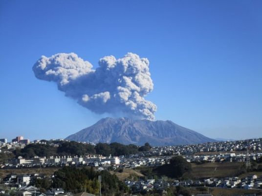 火山の噴煙を背景にした街