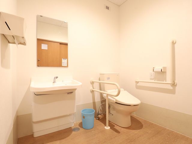 バリアフリーのトイレ スライドショー 安心してご利用いただける、手すり付きの清潔なトイレ空間です。利用しやすいように工夫された配慮が感じられます。