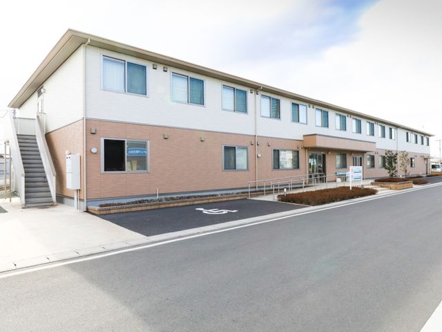 施設の明るい外観 スライドショー 機能的な造りの建物が整っており、アクセスも良好です。働く環境としても快適さが感じられる明朗な空間です。