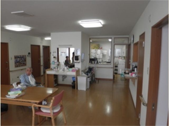 居室とスタッフの様子 リビング 広々とした清潔感のあふれる居室です。利用者とスタッフのコミュニケーションも活発に行われています。
