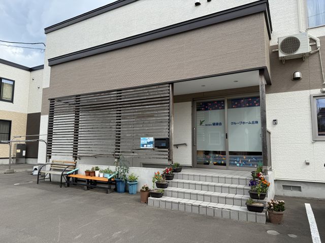 階段のある入口 エントランス 玄関の階段脇には、色とりどりの花が並び、季節を感じることができます。バリアフリーの工夫が見られます。