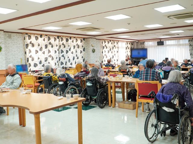 多様な人々の食堂 共有スペース ゆったりした食事の空間で様々な方々が心地よい時間を過ごしています。温かい光が差し込む明るい食堂です。