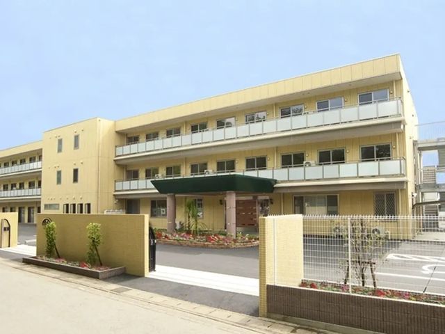 明るい外観の建物 外観   淡い色合いの3階建ての建物です。花壇やひさしが整えられ、落ち着いた雰囲気があります。