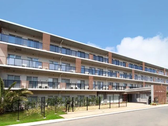 建物外観 外観   青空の下に、バルコニーが並ぶ落ち着いた建物です。広い前面スペースがあり、明るい雰囲気が伝わります。