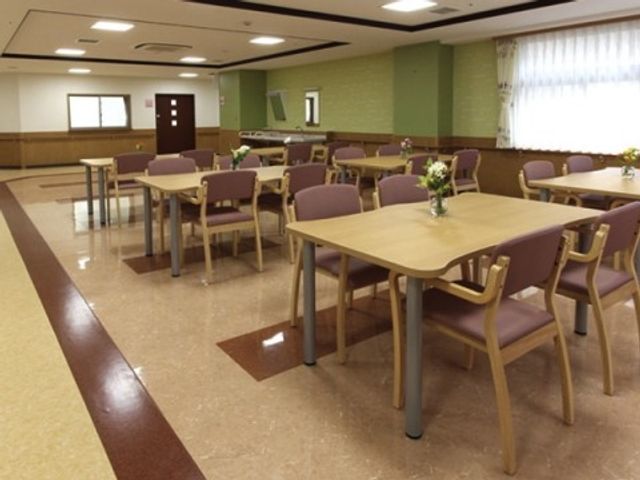 ゆったり食堂空間 談話コーナー 広々とした食堂は、明るく清潔感のある造りです。テーブルごとに花が飾られ、心地よい食事の時間を過ごせそうです。