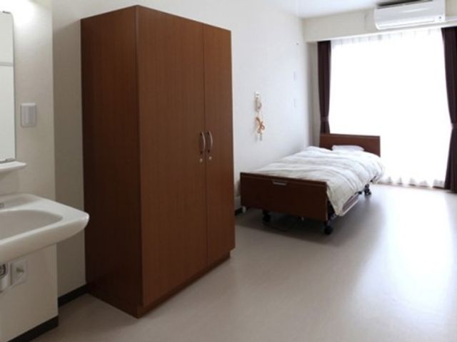シンプルな居室の様子 居室 床が清潔で明るい個室には、必要な家具が整っており、穏やかな生活を送ることができそうです。窓からの自然光が室内を温かく照らしています。