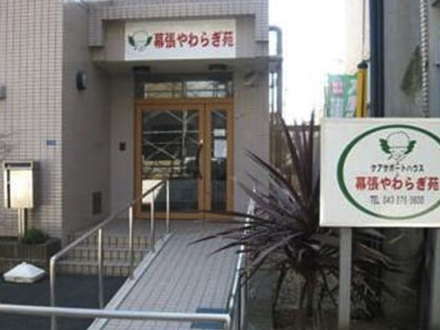 建物正面と看板 施設外観 アクセスしやすい位置にある明るいエントランスです。清潔感のある建物前には、情報提供のための看板が設置されています。
