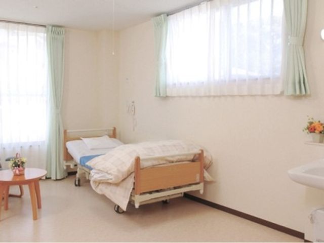明るい個室の居室 居室 開放的な居室はベッドと洗面台を完備しており、快適な生活空間が整っています。窓からの自然光が心地よく差し込み、温かな雰囲気を醸し出しています。