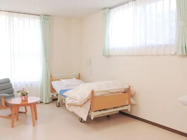 明るい居室 居室   大きな窓から自然光が入る、明るく落ち着いた居室です。ベッド横に椅子とテーブルがあり、くつろぎやすい雰囲気です。