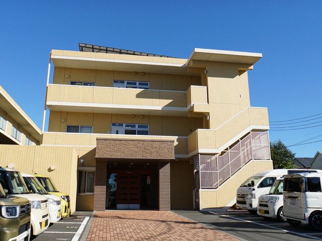 黄色い建物の外観 外観 明るい色合いの建物は、清潔感があり歓迎する雰囲気です。緑豊かな地域に位置しており、静かで穏やかな環境が広がっています。