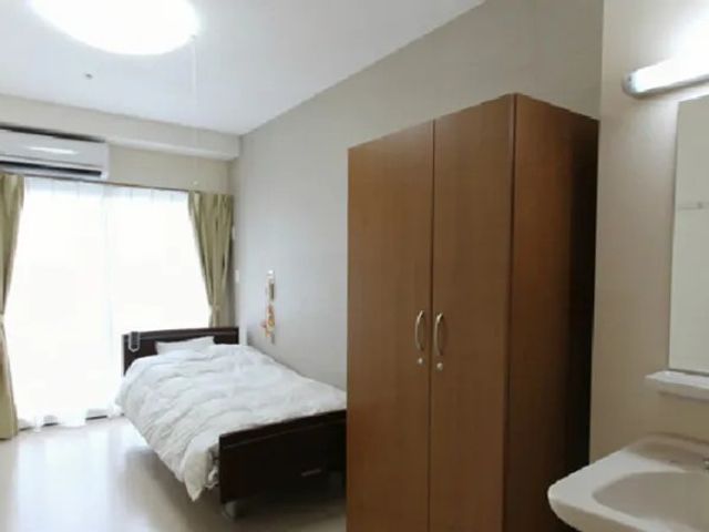 居室のベッドと収納 居室   明るい居室にベッドと大きな収納が配置されています。窓から光が入り、落ち着いて過ごしやすそうです。