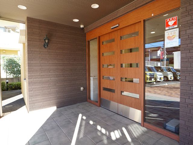 温かみのある木目調エントランス 玄関 陽光溢れる落ち着いた入り口には、AEDの設置も確認でき安心です。