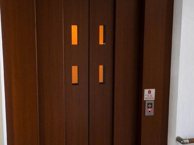 茶色のエレベーターの扉 エレベーター 清潔で使いやすいデザインの移動手段を備え、安全に配慮されています。