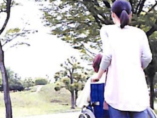 車椅子を押す人の背中