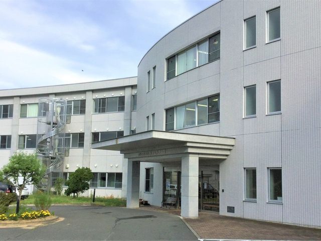 外観の正面玄関 外観   白い外壁の建物で、正面玄関には屋根付きの車寄せがあります。窓が多く、落ち着いた印象です。