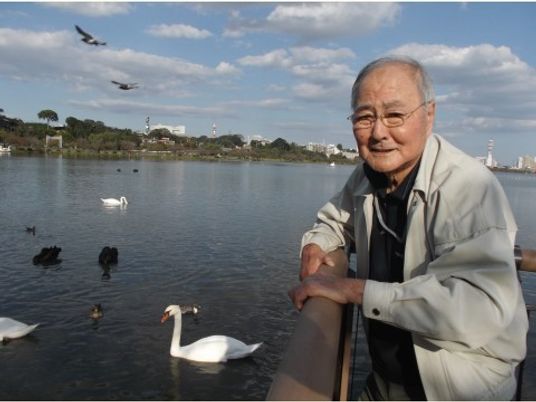 笑顔のおじいさんと白鳥の湖畔