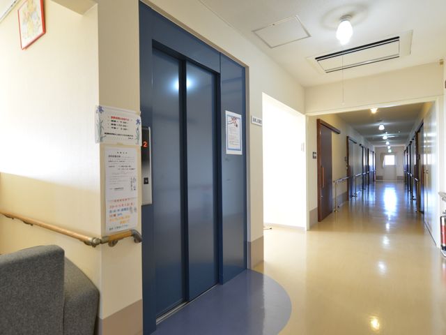 清潔な廊下とエレベーター エレベーター前ホール 廊下は広々としており、手すりが整備されているため、安心して歩行できます。また、エレベーターも設置されており、階段の昇降が困難な方も快適に移動が可能です。