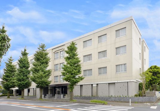 緑豊かな通りがある建物の外観