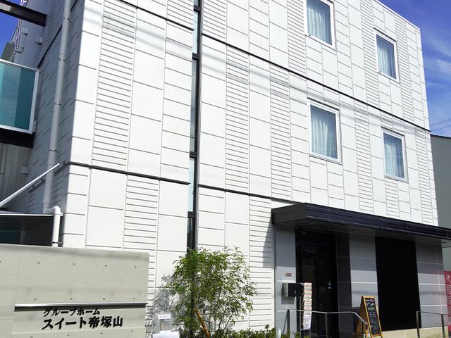 白い壁の建物のエントランス 外観 清潔感のある外壁が目を引く建物です。スタッフとして迎える訪問者の第一印象を大切にできる場所になります。