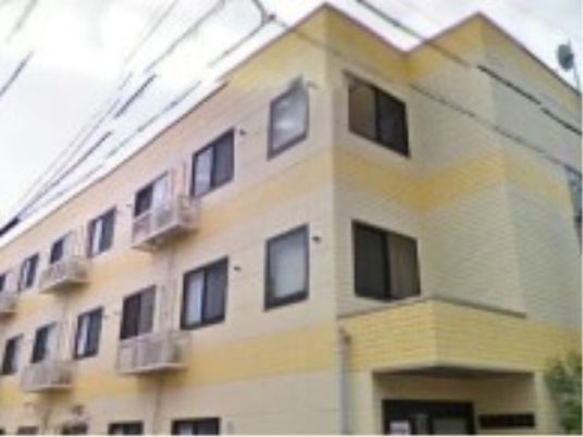 黄色い外壁の建物外観