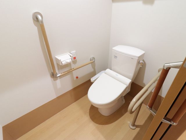 バリアフリー設計のトイレ トイレ  手すりが付いた清潔なトイレ空間です。安全に配慮された設計で、働く環境の一角をご覧いただけます。