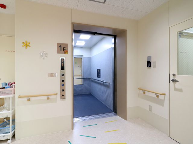廊下とエレベーターの画 エレベーター 安定した手すりが備わった清潔感のあふれる廊下は、ご高齢者も安心して歩行できるように設計されています。安全かつスムーズに移動をサポートするエレベーターがございます。