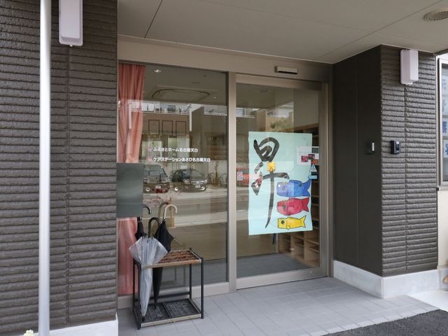 エントランスの自動ドア 玄関 広々としたエントランスは自動ドアで、来訪者の出入りがスムーズです。アート作品が飾られ、温かな雰囲気を醸し出しています。