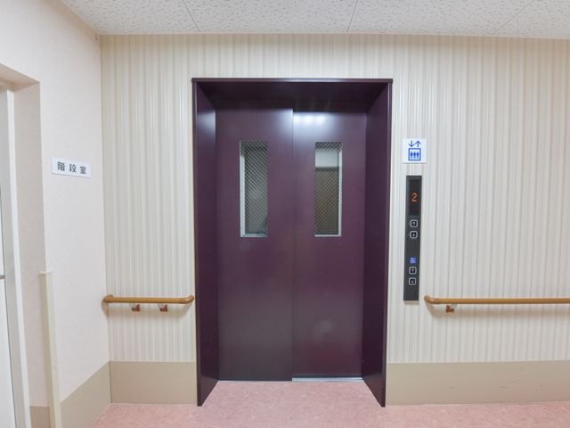 清潔なエレベーター前 エレベーター 手すり付きの広々とした通路で、どなたでも安全にエレベーターをご利用いただけます。安心のバリアフリー設計です。